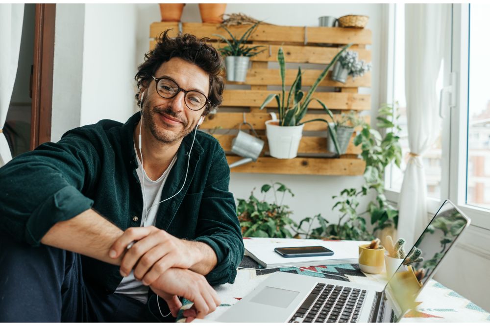 Man with laptop and smartphone working remotely from home