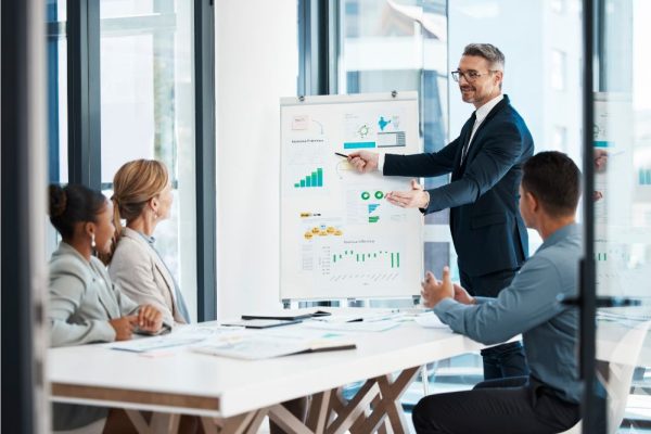 meeting of a corporate man showing finance data to team